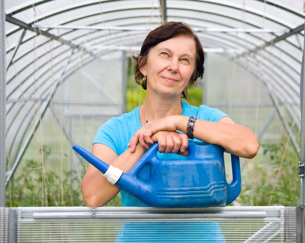 stock image Woman with watering in the greenhouse