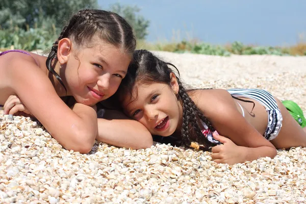 Duas meninas jazem na praia — Fotografia de Stock