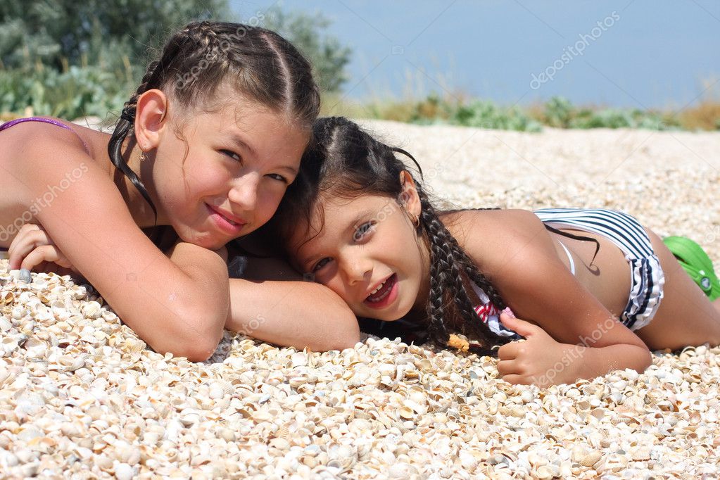Two girls lie on beach