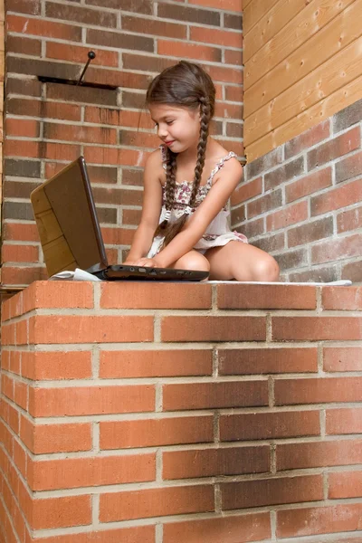 Flicka med laptop sitter på ryska spis — Stockfoto