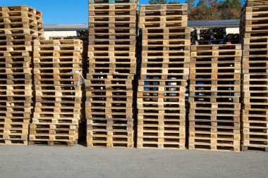 Pallets stacked in a pile outside clipart