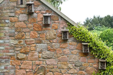 Small insect hotels on a house wall clipart