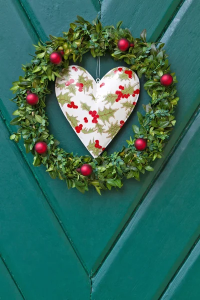 De kroon van Kerstmis opgehangen op een houten deur — Stockfoto