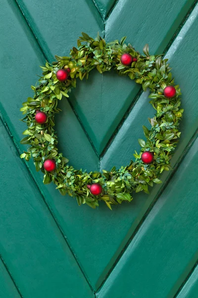 Vánoční věnec pověsit na dřevěné dveře — Stock fotografie