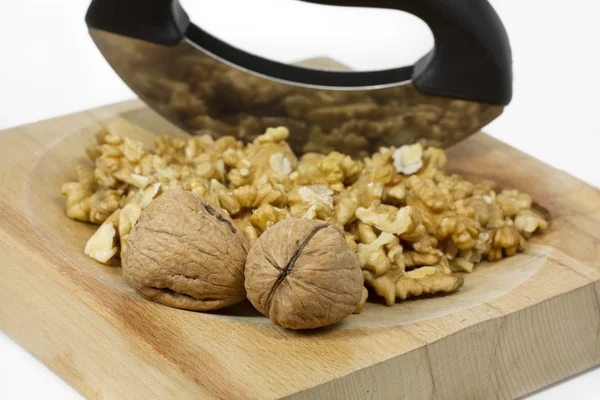 Nueces en un plato de madera con cuchillo de cortar —  Fotos de Stock