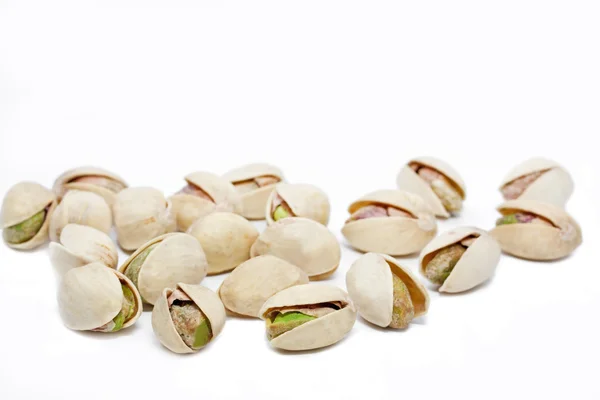 Фисташковые орехи на белом фоне, мелкий DOF — стоковое фото