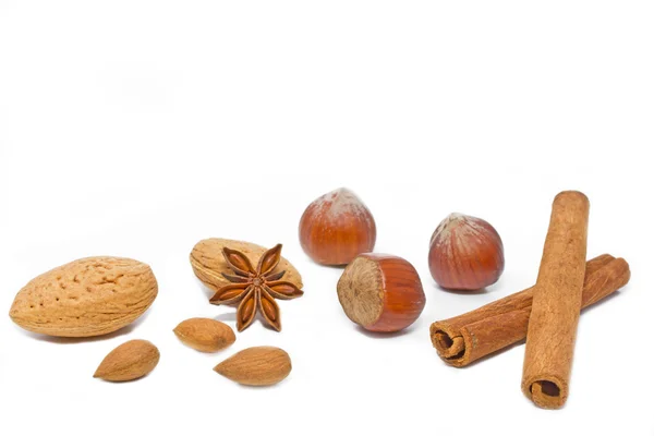 Ořechy a skořicí hole na bílém pozadí — Stock fotografie