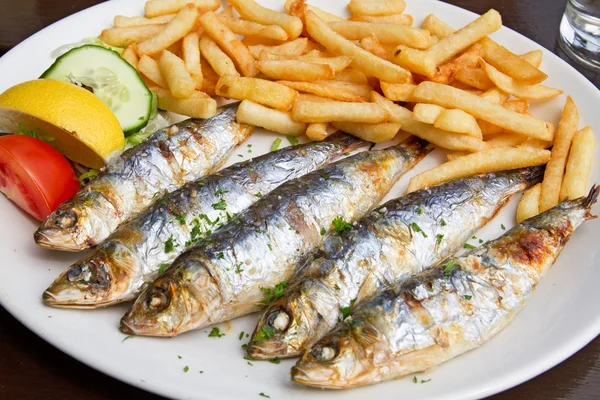 Grilované sardinky ryby a hranolky sloužil na talíři — Stock fotografie