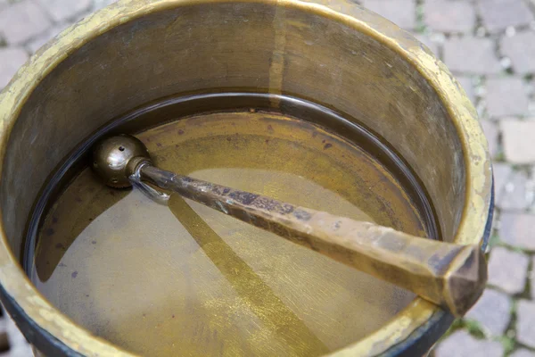 真ちゅう製の鍋の聖水 — ストック写真