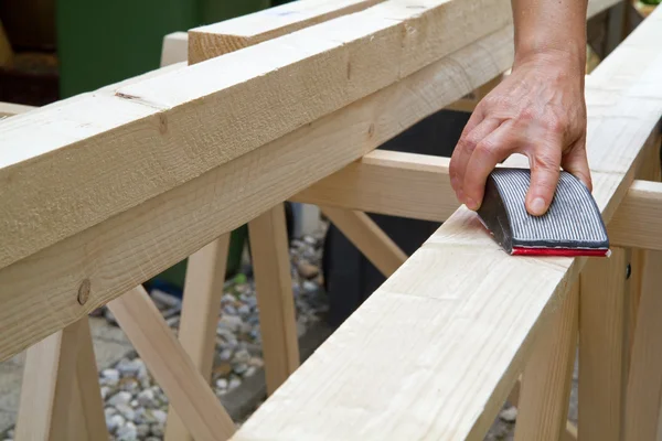 Manually grinding a wooden beam — Stock Photo, Image