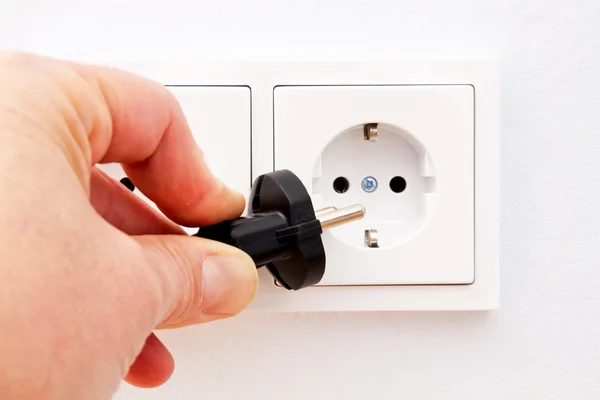 Putting a plug in an electrical outlet — Stock Photo, Image