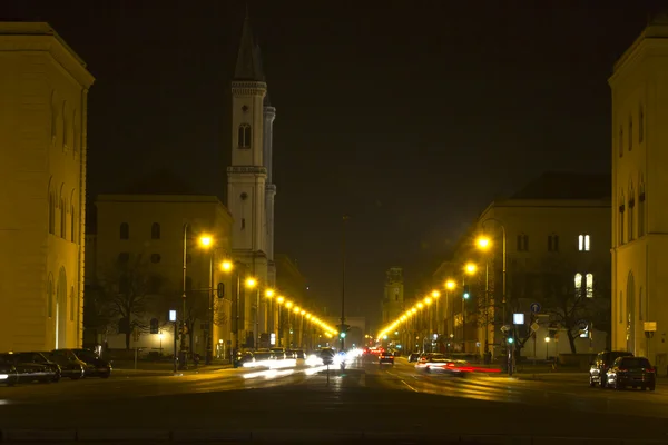 La famosa calle Leopoldstreet con la iglesia Ludwigskirche en Munich por la noche — Foto de Stock