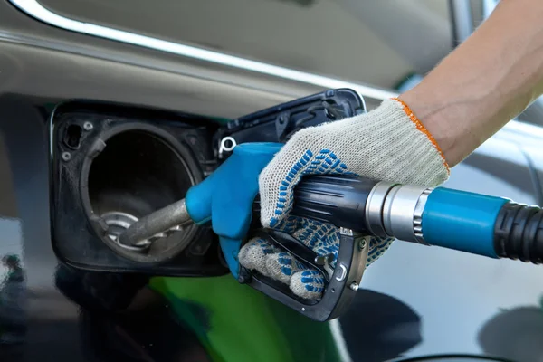 Gros plan d'une main d'homme remplissant la voiture avec une pompe à essence — Photo