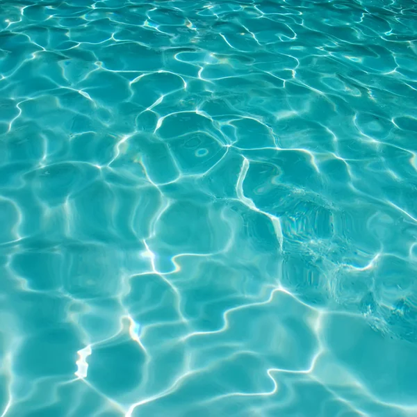 Achtergrond van rimpelend patroon van schoon water in een blauw zwembad — Stockfoto