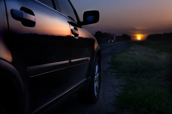 Lüks bir araba arka tarafı görünümünü günbatımı üzerinde — Stok fotoğraf