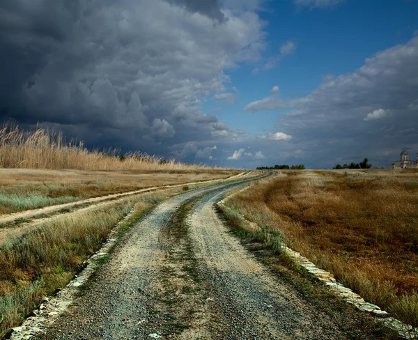 A estrada através do antigo campo de relva — Fotografia de Stock