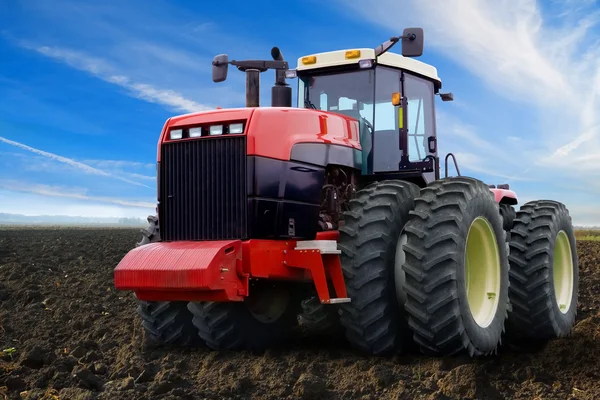 Traktorn på ett grönt fält — Stockfoto
