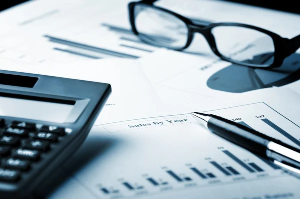 Szemüveg, számológép, toll és üzleti diagram — Stock Fotó