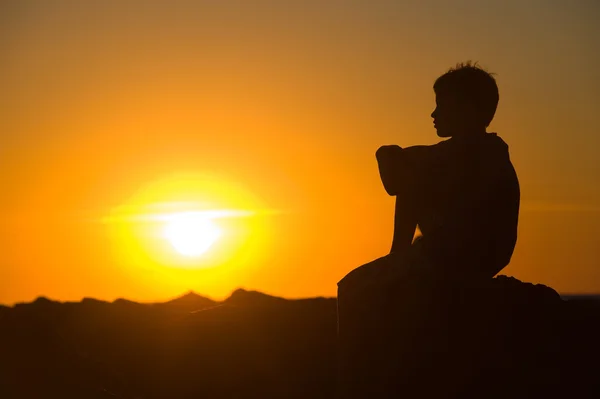 Молодий хлопчик насолоджується заходом сонця — стокове фото