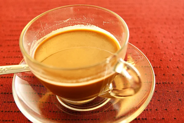 Cup of coffee on the table in red. Stock Picture