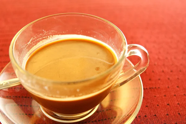 stock image Cup of coffee on the table in red.