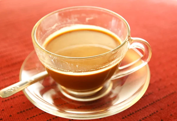 stock image Cup of coffee on the table in red.