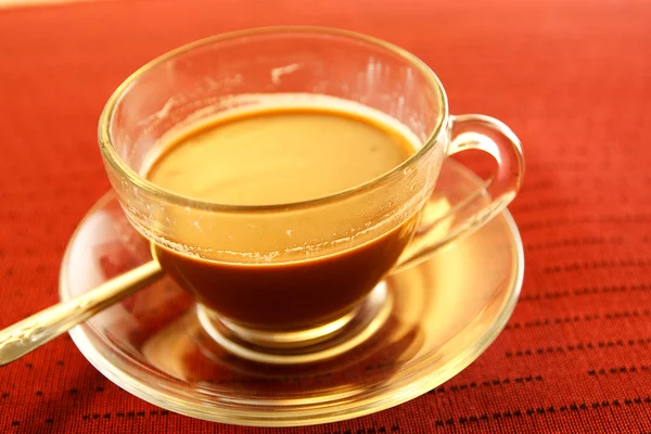 Šálek kávy na stole v červené barvě. — Stock fotografie