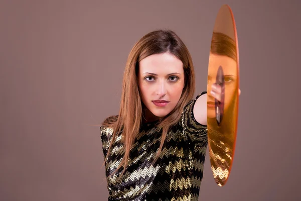 Krásná blonďatá žena stojící drží zlatý vinyl disk, studio zastřelil — Stock fotografie