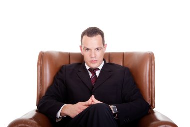 Businessman seated on a chair, isolated on white background. Studio shot. clipart