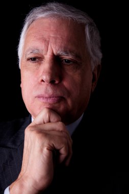 Portrait of a handsome mature businessman, on black background, studio shot clipart