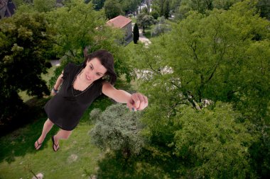 Uçuş, backgroung olarak ağaçları ile genç bir kadın