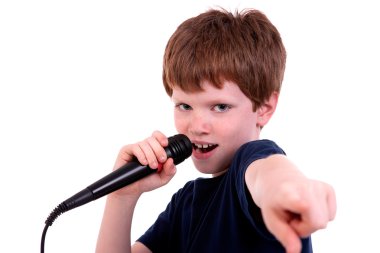 Cute boy with a microphone sings isolated on white, studio shot clipart