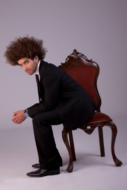 yakışıklı iş adamı vurdu studio bir sandalyede oturuyor,.