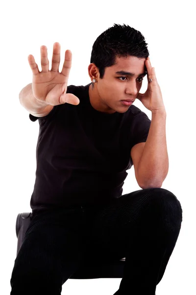 Joven latino, pensativo, con su mano en señal de stop, aislado sobre fondo blanco, plano de estudio — Foto de Stock