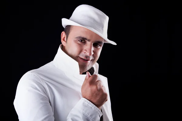 Lächelnder Mann mit weißem Hut und Mantel, isoliert auf schwarz. Studioaufnahme — Stockfoto