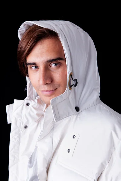 Retrato de um jovem vestindo um casaco branco com capuz, isolado em preto. Estúdio — Fotografia de Stock