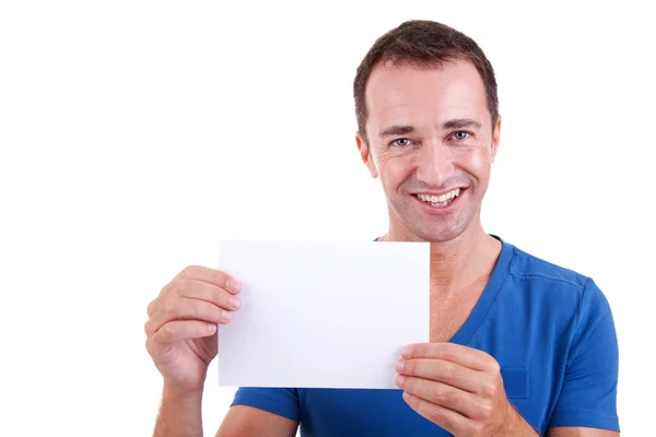 Man holding a white card, smiling and looking to camera, isolated on a white background. Studio shot. — Stock Photo, Image