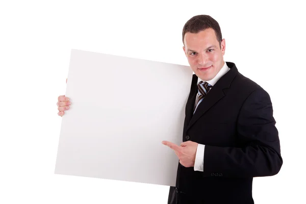 Stilig affärsman innehar en whiteboard och pekar, titta på kameran och leende — Stockfoto