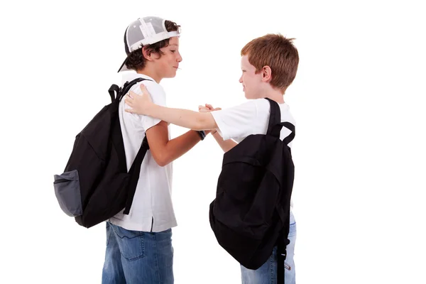 Boys going to school, greeting one another, seen from the back, on white, studio shot — Stock Photo, Image