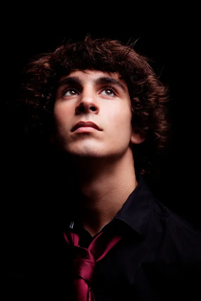 Young man looking up , isolated on black, studio shot — Stock Photo, Image
