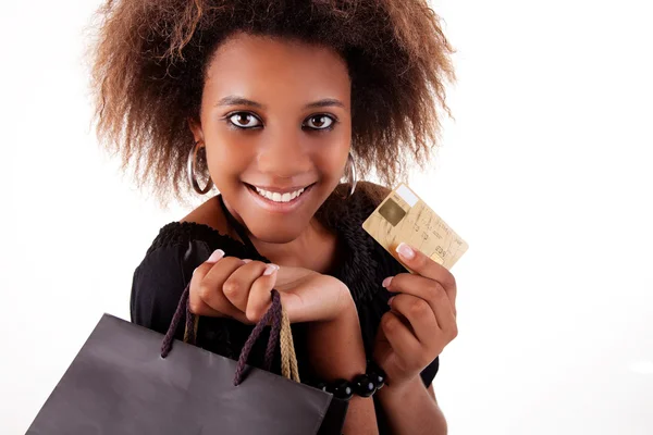 Chica negra feliz con bolsas de compras y tarjeta de crédito, aislado sobre un fondo blanco. Captura de estudio . —  Fotos de Stock