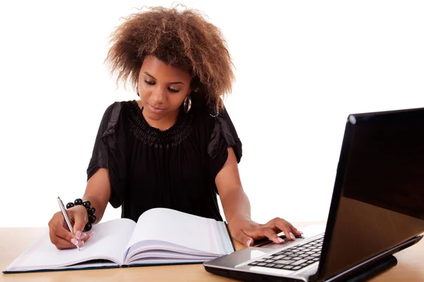 年轻的黑人妇女工作用的计算机上，在白色背景上孤立的办公桌上。工作室拍摄. — 图库照片