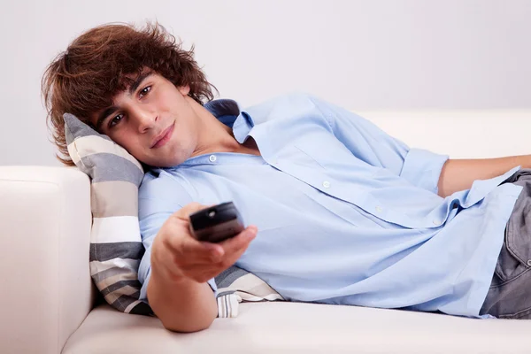 若い男が、手でコマンドでテレビを見ています。 — ストック写真