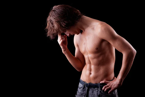 stock image A tired and sweat young man in topless, isolated on black. Studio shot.