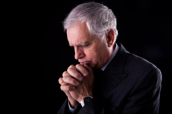 Portrait of a handsome mature businessman, thinking-praying, on black background, studio shot — Stock Photo, Image