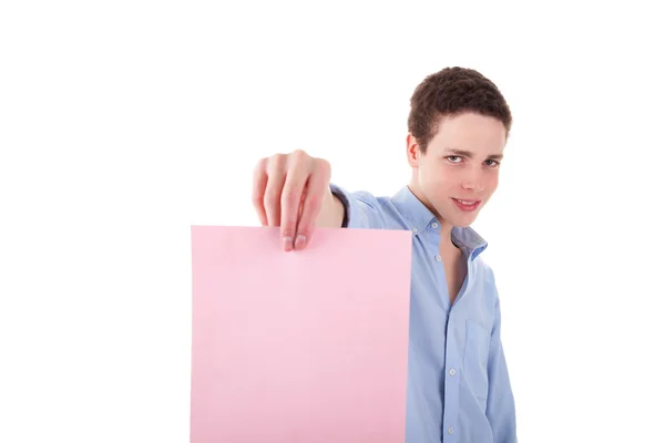 Młody człowiek uśmiechający się trzyma arkusz różowy papier w ręce, na białym tle na białym tle. łapka. — Zdjęcie stockowe