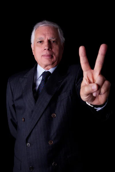 Businessman with thumb raised as a sign victory, isolated on black background. studio shot — Stock Photo, Image