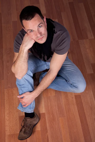 Homem bonito, sentado no chão — Fotografia de Stock