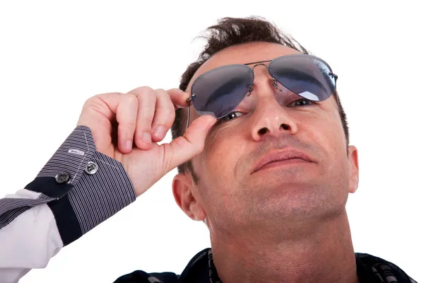 Портрет красивого чоловіка середнього віку з сонячними окулярами, який дивиться вниз, на білому тлі. Студійний знімок — стокове фото