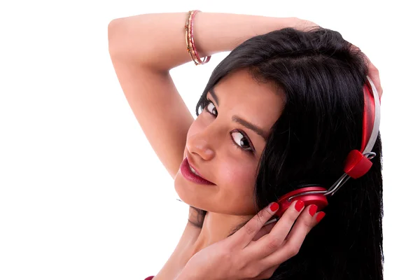 Όμορφη γυναίκα να στέκεται, να ακούτε μουσική στα ακουστικά κόκκινο, απομονωθεί σε λευκό, studio που γυρίστηκε — Φωτογραφία Αρχείου